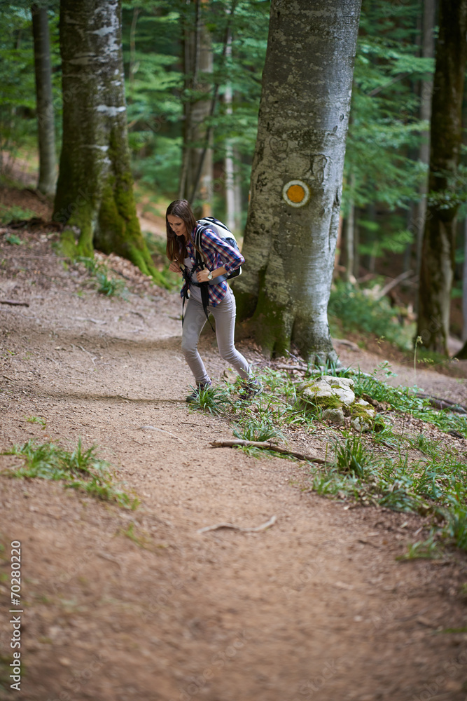 Fototapeta premium Woman with backpack hiking into the forest