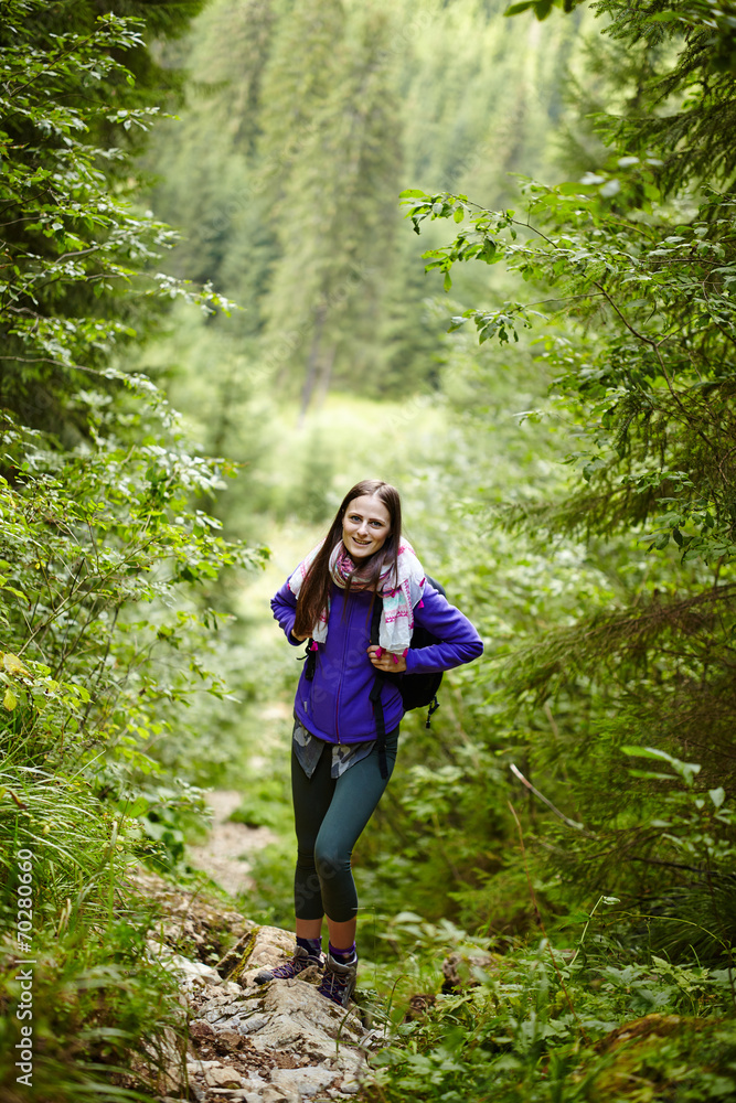 Woman with backpack hiking into the forest Woman with backpack hiking into the forest