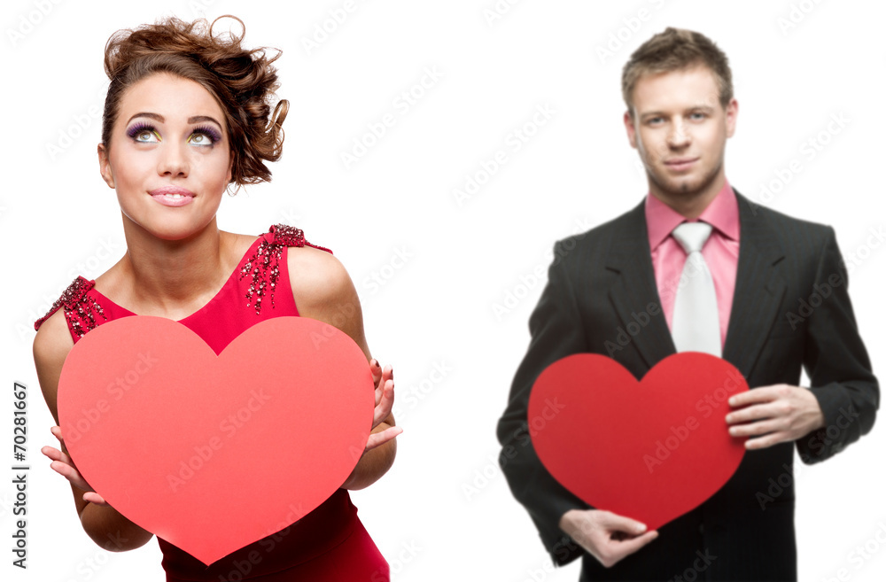 young cheerful woman and handsome man holding red heart on white