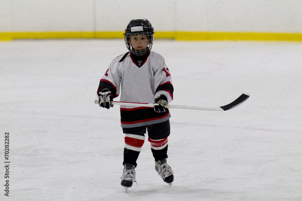Obraz premium Little boy playing ice hockey