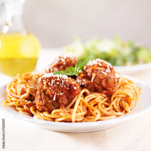 spaghetti and meatballs with oil and salad
