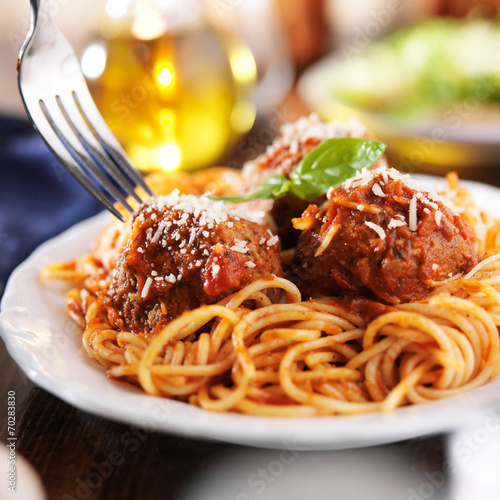eating a plate of spaghetti and meatballs with fork