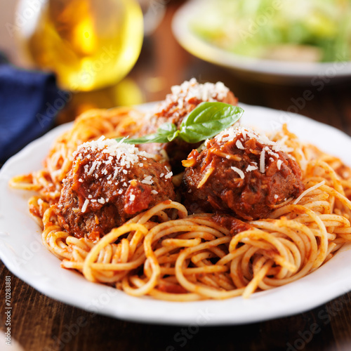 spaghetti and meatballs at cluttered dinner table photo