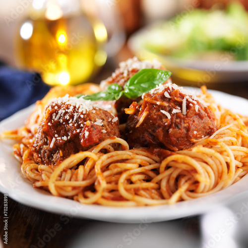 spaghetti and meatballs at cluttered dinner table