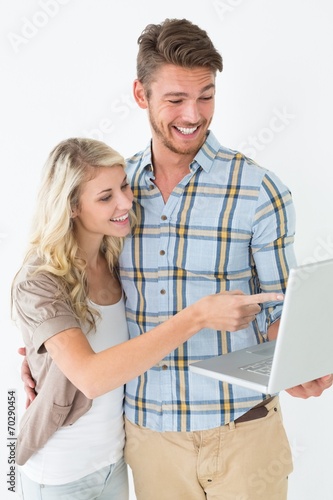 Happy attractive young couple using laptop © WavebreakMediaMicro