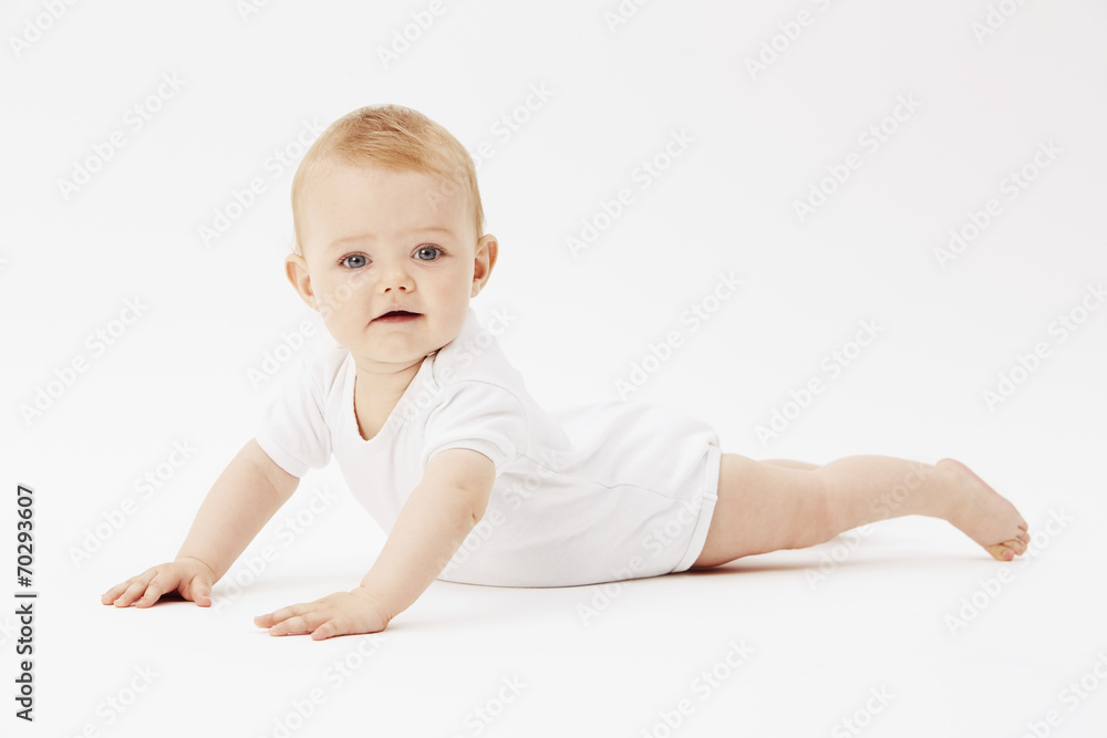 Young baby girl crawling on front, studio.