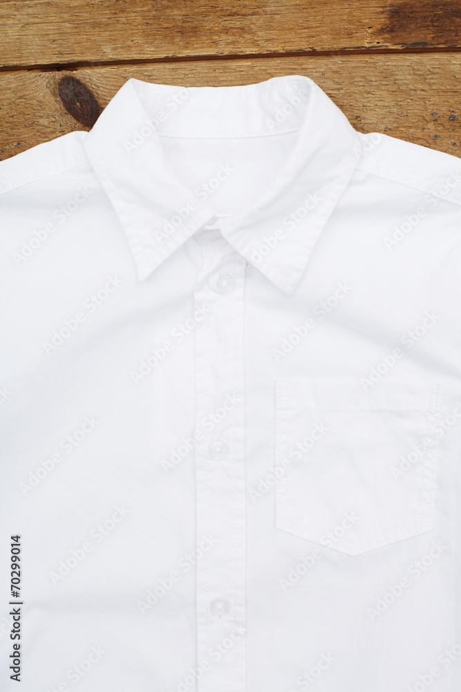 White short sleeved shirt against wooden wall. White short sleeved shirt against wooden wall.