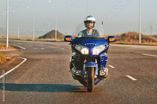 man riding a motorcycle on an open road
