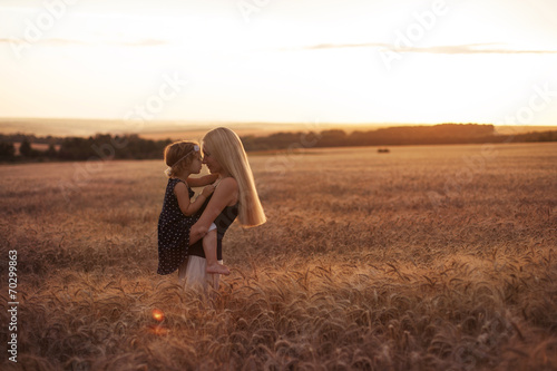 Mother and daugther on the field at the sunset photo