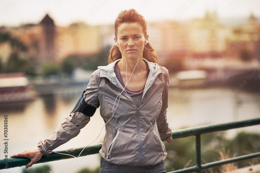 Fototapeta premium Portrait of fitness young woman in the city in the evening