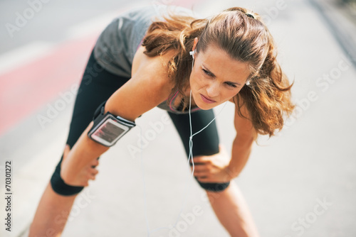 Photos Portrait of tired fitness young woman outdoors in the city