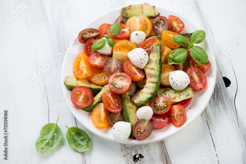 Salad with grilled avocado, various types of tomatoes and cheese