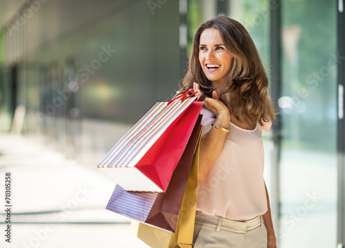 Happy young woman with shopping bags on the mall alley