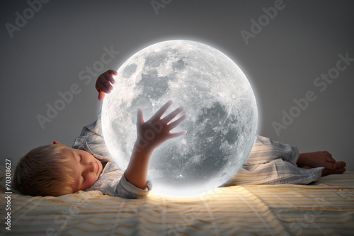 Kind mit Mond im Bett photo
