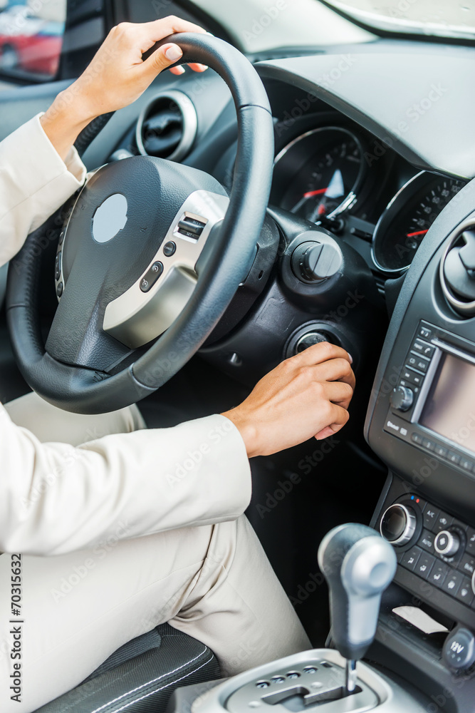 Woman starting a car.