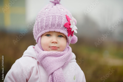 Beautiful smiling little girl in pink coat close up