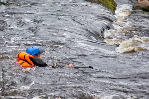 Fotografija people in life jackets drowning in a turbulent river