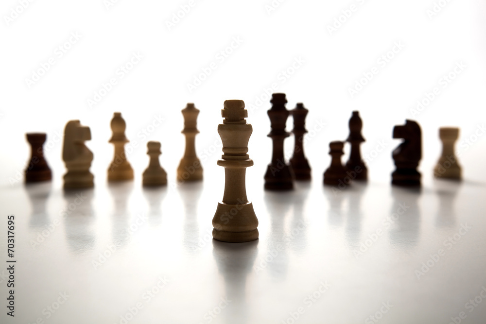 chess pieces lined up in a row on a gray chess pieces lined up in a row on a gray