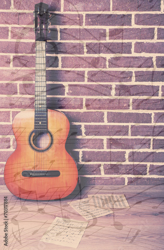 Guitar on floor on brick wall background © Africa Studio