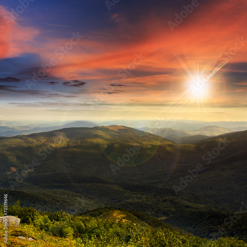 stone mountain slope with forest at sunset