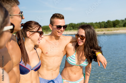 smiling friends in sunglasses on summer beach © Syda Productions
