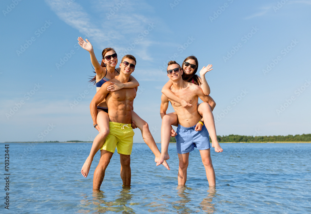 smiling friends in sunglasses on summer beach - obrazy, fototapety, plakaty 