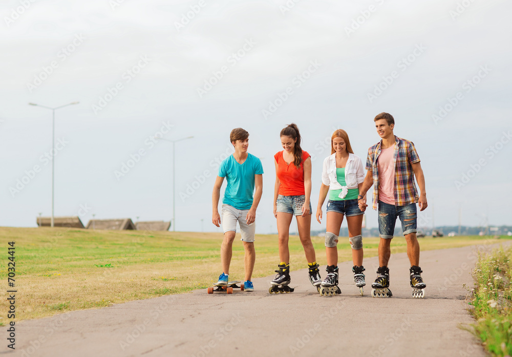 Fototapeta premium group of smiling teenagers with roller-skates