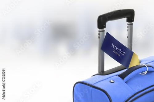 Canvas Print Istanbul, Turkey. Blue suitcase with label at airport.