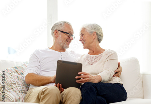 happy senior couple with tablet pc at home