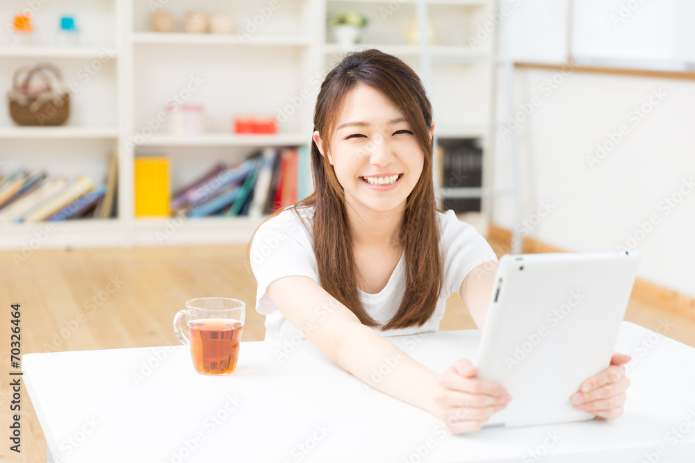 部屋でタブレットを見る女性 部屋でタブレットを見る女性