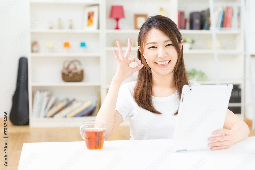 部屋でタブレットを見る女性 部屋でタブレットを見る女性