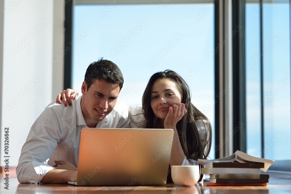 relaxed young couple working on laptop computer at home relaxed young couple working on laptop computer at home
