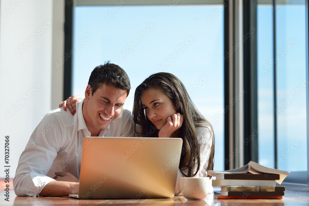 relaxed young couple working on laptop computer at home relaxed young couple working on laptop computer at home