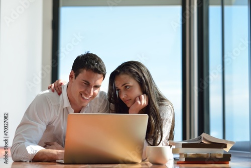 relaxed young couple working on laptop computer at home