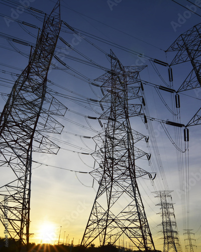 Silhouette of high power transmission towers at sunset