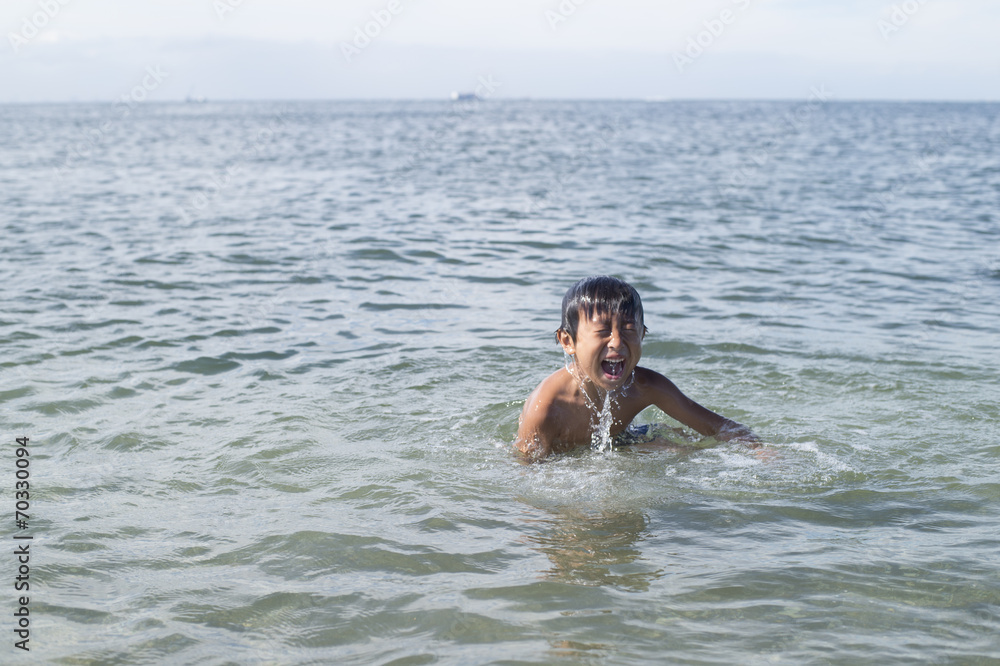 Boy playing and diving in the ocean