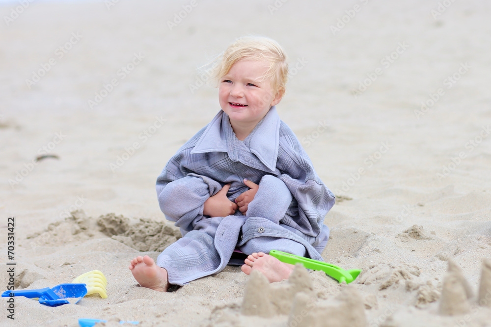 Little happy girl building sand castles on the beach Little happy girl building sand castles on the beach