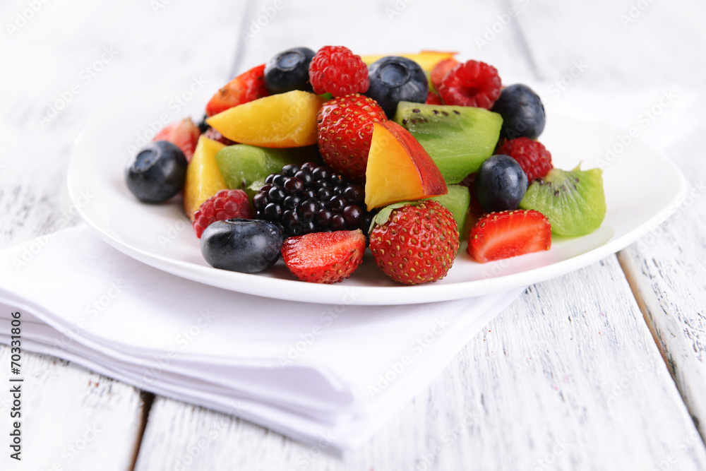 Delicious fruits salad in plate on table close-up Delicious fruits salad in plate on table close-up