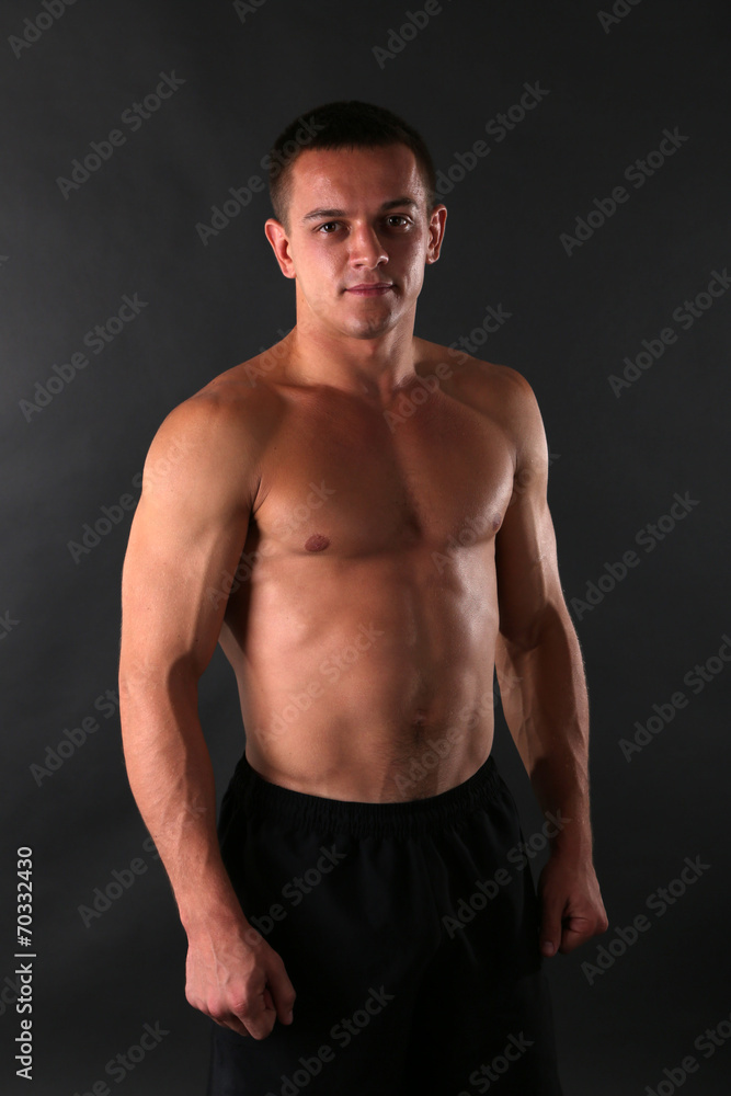 Fototapeta premium Handsome muscle young man on dark background