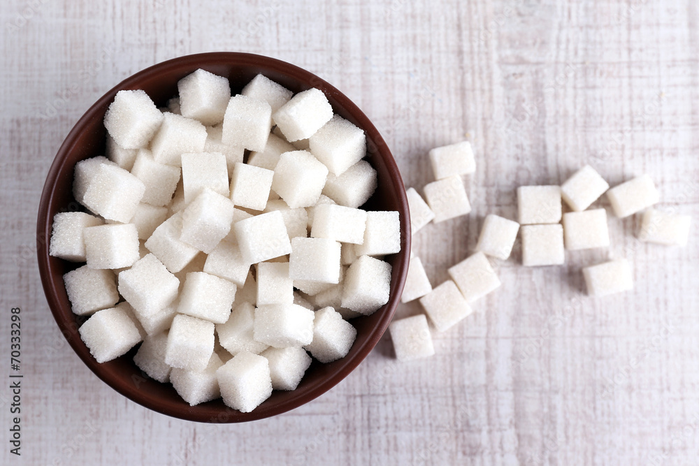 Refined sugar in color bowl on wooden background Refined sugar in color bowl on wooden background