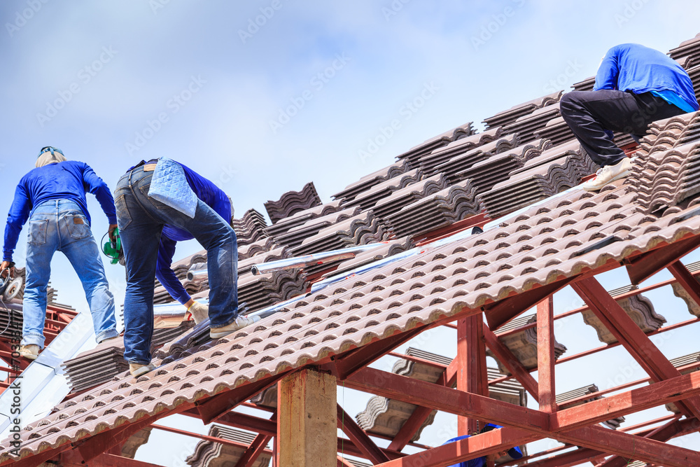 Worker install roof tile for new house