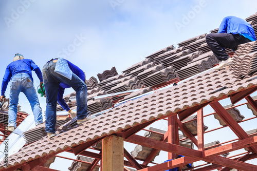 Worker install roof tile for new house
