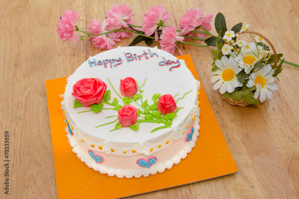 Cream cake with rose on the wooden table
