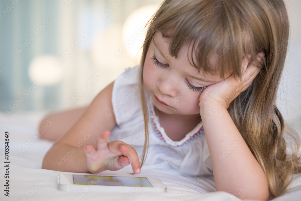 Cute Little girl using mobile phone at home Cute Little girl using mobile phone at home