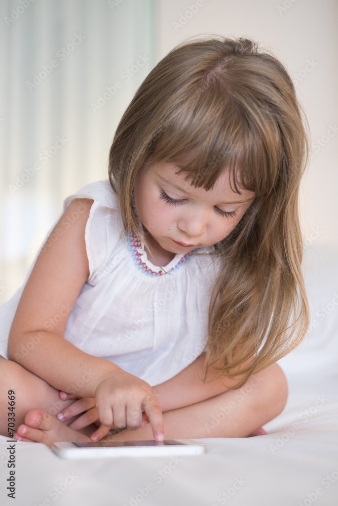 Cute Little girl using mobile phone at home Cute Little girl using mobile phone at home