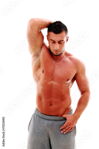 Portrait of muscular man showing his body over white background