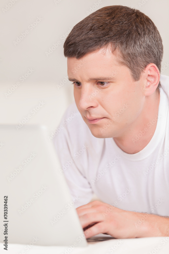Man lying in bed with his laptop. Man lying in bed with his laptop.