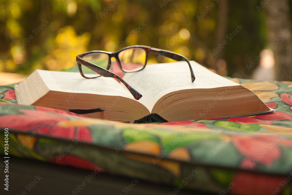 Książka z okularami leży na kolorowym materacu - obrazy, fototapety, plakaty 