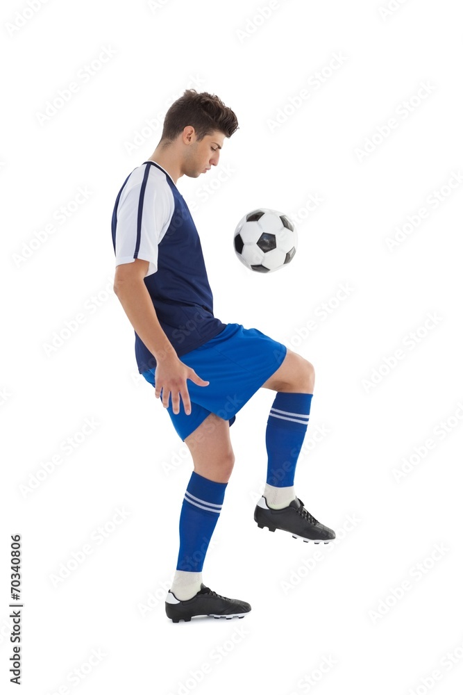 Fit football player playing with ball Fit football player playing with ball