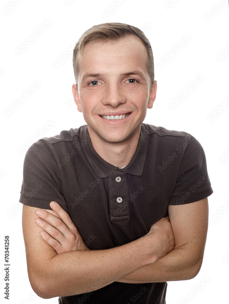 A young man with a smile, standing with arms crossed on a white A young man with a smile, standing with arms crossed on a white